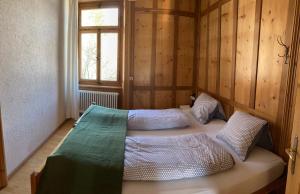 um quarto com 2 camas num quarto com uma janela em Felsahus em Alvaneu