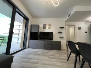 a living room with a television and a table and chairs at Kibilù - Cascina Merlata Rho Fiera Ospedale Galeazzi in Pero