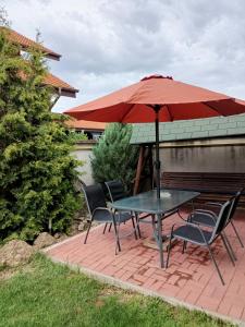 Una mesa y sillas con una sombrilla en un patio. en Cozy Apartments, en Timisoara