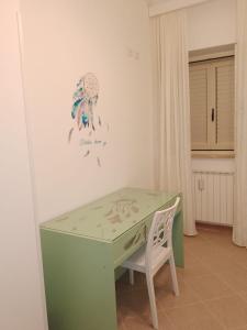 a green desk with a chair in a room at A' Ches du' Mestr 1 in Montalbano