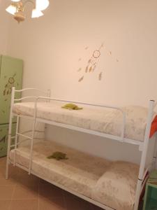 Ce lit se trouve dans un dortoir doté de 2 lits superposés et d'un mur. dans l'établissement A' Ches du' Mestr 1, à Montalbano