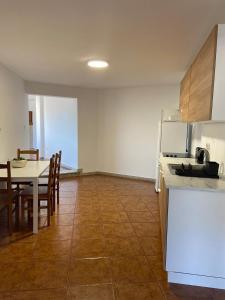 eine Küche und ein Esszimmer mit einem Tisch und einem Kühlschrank in der Unterkunft Casa Rodrigues in Terras de Bouro + 8 Fotos