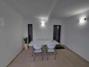 a white table and chairs in a room at Casa Rodrigues in Terras de Bouro +4 photos