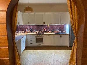 a kitchen with white cabinets and a stove top oven at Wichrowe Wzgorze in Stronie Śląskie