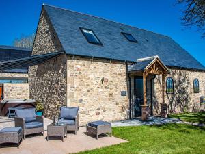 a stone building with chairs and a patio at Woodland View in Richmond