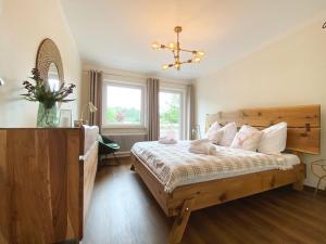 sypialnia z drewnianym łóżkiem i oknem w obiekcie Sunny Apartment Maria Alm w mieście Maria Alm am Steinernen Meer