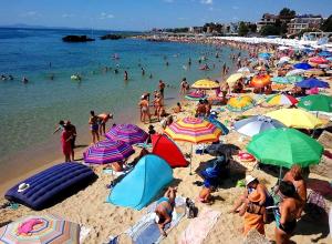 a crowd of people on a beach with umbrellas at Sunny House Family in Nesebar