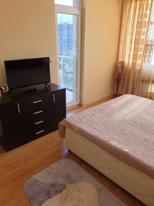 a bedroom with a bed and a flat screen tv at Sunny House Family in Nesebar