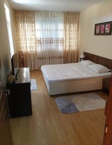 a bedroom with a large bed and a window at Sunny House Family in Nesebar