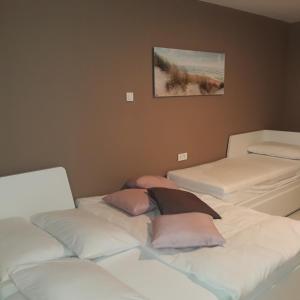 una camera con tre letti con cuscini rosa di APP Nina Portoroz a Portoroz
