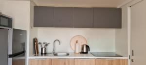 a kitchen with gray cabinets and a sink at TAKE IT EASY Mobile Home, Camp Basko Polje #New2022 in Baška Voda