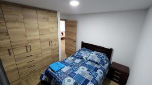 a bedroom with a bed and wooden cabinets at Departamento completo de dos habitaciones la Estación del Tren 3 in Riobamba