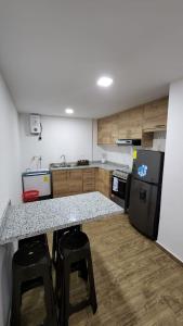 a kitchen with a black refrigerator and a counter top at Departamento completo de dos habitaciones la Estación del Tren 3 in Riobamba