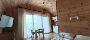 Schlafzimmer mit einem Bett, einem Schreibtisch und einem Fenster in der Unterkunft Gemini MiniDomki in Ustka