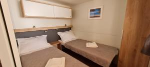 a small room with two beds and a window at TAKE IT EASY Mobile Home, Camp Basko Polje #New2022 in Baška Voda
