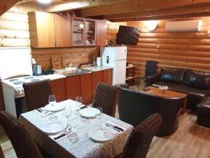 a dining room with a table and chairs and a kitchen at Holiday House Kruce in Ulcinj