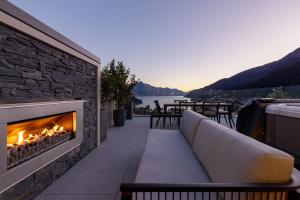 a fireplace on a patio with a view of a lake at The Carlin Boutique Hotel in Queenstown
