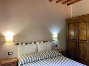 1 dormitorio con 1 cama y 2 luces en la pared en Agriturismo La Vecchia Quercia, en Montemerano