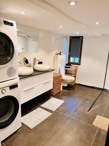 a bathroom with a sink and a washing machine at La tanière de Bonneville in Bonneville-sur-Touques