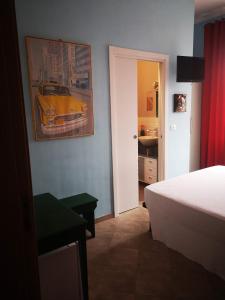 - une chambre avec un lit et une photo d'une voiture sur le mur dans l'établissement Bibi a Mare, à Finale Ligure