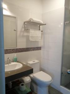 een badkamer met een toilet, een wastafel en een spiegel bij NEREO rooms in Lima