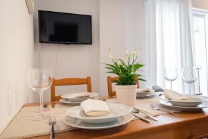 una mesa de comedor con platos y copas de vino en Like Home Sevilla - Museo, en Sevilla