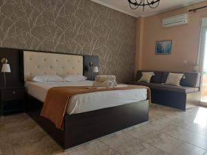 a bedroom with a large bed and a couch at Hotel Epavli in Nea Kallikrateia