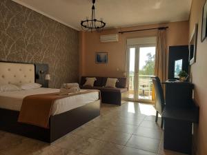 a bedroom with a bed and a couch and a window at Hotel Epavli in Nea Kalikratia