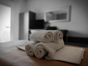 a stack of towels sitting on top of a bed at Hotel Epavli in Nea Kalikratia