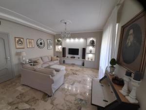 un salon avec un canapé blanc et une télévision dans l'établissement La Casa di Luzzo, à Agrigente