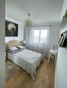 a bedroom with a large bed and a chandelier at LUX Apartment Amazing View in Wrocław