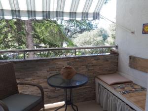 einen Balkon mit einem Tisch und Stühlen sowie einem Fenster in der Unterkunft Apartment Green Note in Split