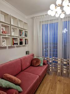 a living room with a red couch and a window at LUX Apartment Amazing View in Wrocław