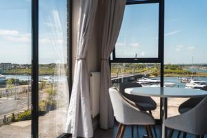 a balcony with a table and chairs and a view of a marina at Penthouse - Harbour Views in Poole