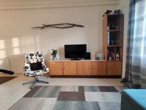 a living room with a tv and a chair at Beach Front Apartment in Gafanha da Nazaré