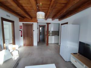 een woonkamer met een witte koelkast en houten plafonds bij PEÑAFIEL DREAMS CON JACUZZI 4 PERSONAS in Peñafiel