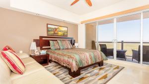 a bedroom with a bed and a couch and a window at Encanto Living 1104 by Kivoya in Puerto Peñasco