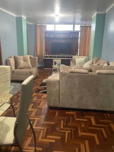 uma sala de estar com 2 sofás e uma televisão de ecrã plano em Hermosos Departamentos con Vista a los Nevados em Riobamba