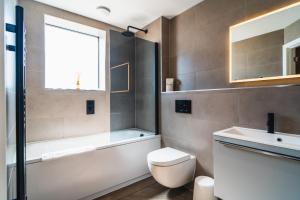 a bathroom with a tub and a toilet and a sink at No. Two - Harbour Views in Poole