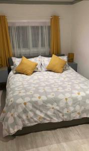 a large bed with yellow pillows in a bedroom at Rye- Tillingham Rye - LOCATION LOCATION LOCATION! in Rye