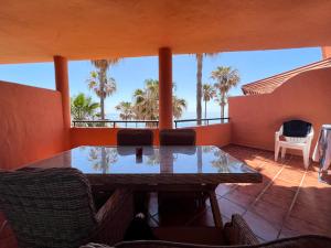stół i krzesła na balkonie z palmami w obiekcie Luxury three bedroom apartment at Estepona w mieście Estepona
