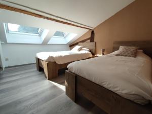 1 dormitorio con 2 camas y 2 tragaluces en B&B Emmylou, en Gouvy