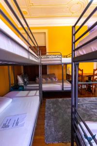 リスボンにあるLisbon Angels Hostelの黄色の壁の客室で、二段ベッド2組が備わります。