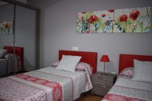 a bedroom with two beds and a painting on the wall at FINCA LA GRANDA DE LA CONCHA in Nueva de Llanes
