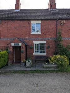 a red brick house with a window and a door at Shepherds Cottage in Shrewsbury