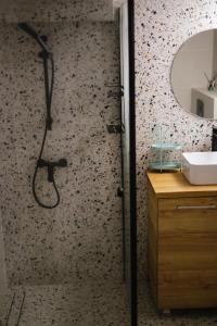 a bathroom with a shower with a sink and a mirror at Domek Mały Las in Rzyki