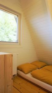 Bett in einem Zimmer mit Fenster in der Unterkunft Domek Mały Las in Rzyki