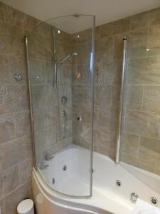 a bathroom with a shower and a tub with a toilet at Shepherds Cottage in Shrewsbury