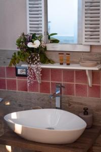 een witte wastafel in een badkamer met een raam bij AGRIB&B Il Pomo d'oro in Assemini