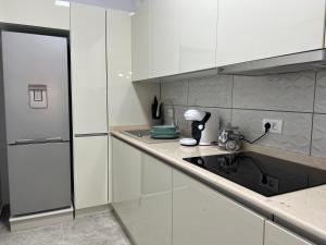 a kitchen with white cabinets and a sink at Sunset Lake Apartments - Mamaia Nord in Mamaia